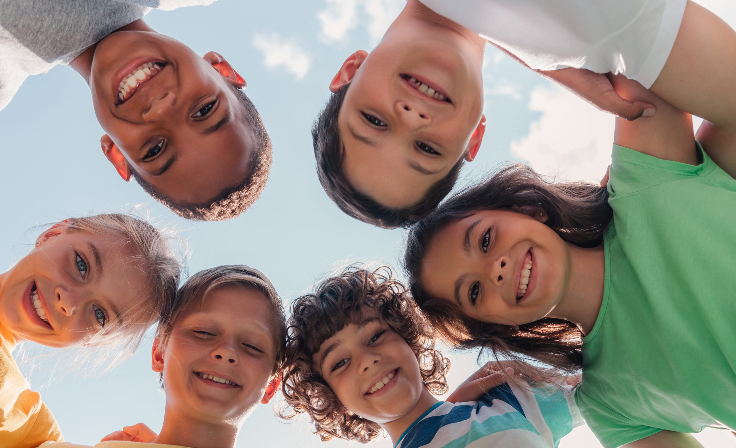 bottom view of smiling multicultural children looking at camera